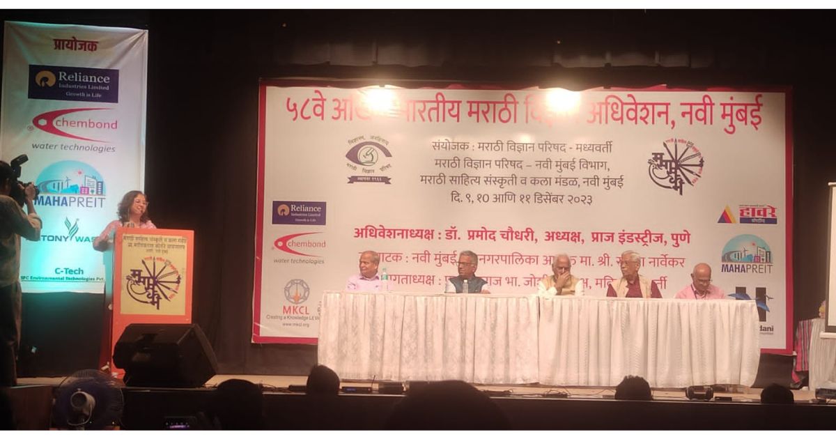 Dipali Akolkar on the stage at the podium of Marathi Vidnyan Parishad and Jyshtharaj Joshi ji Sr. Scientist and Padma Shri along with others is keenly listening.